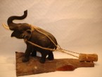 éléphant en pâte de bois tire un bloc sur une piece de bois en teak